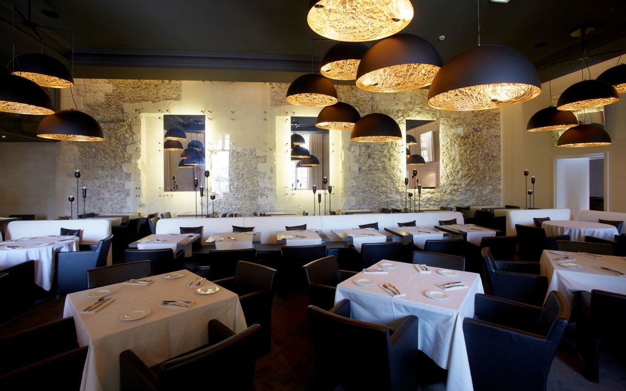 Salle du restaurant les Fenêtres de l'hôtel dieu de Marseille avec une décoration or et texturée, telle une brasserie, designée par le studio d'architecture d'intérieur jean-philippe nuel