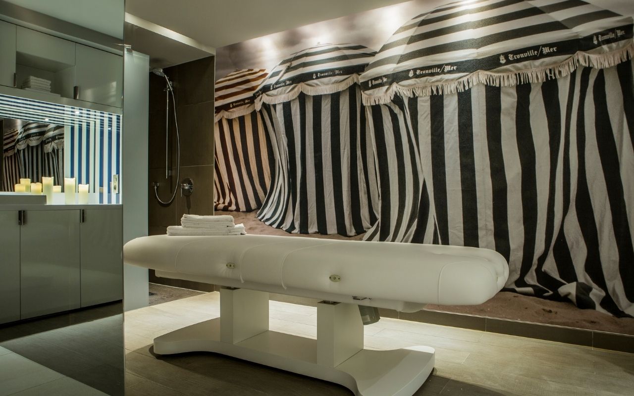 Spa treatment room at the Cures Marines de Trouville hotel, a 5-star luxury hotel designed by the jean-philippe nuel studio in Normandy, high-end treatment, interior design, seaside-inspired decoration, Deauville parasols