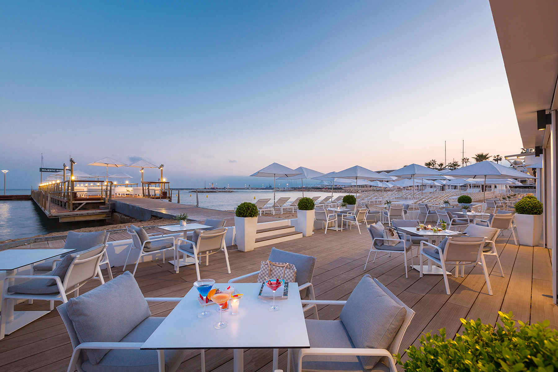 Terrasse de nuit avec vue sur la mer du restaurant le Majestic Barrière à Cannes, sur la côte d'Azur, hôtel barrière 5 étoiles designé par le studio d'architecture d'intérieur jean-philippe nuel