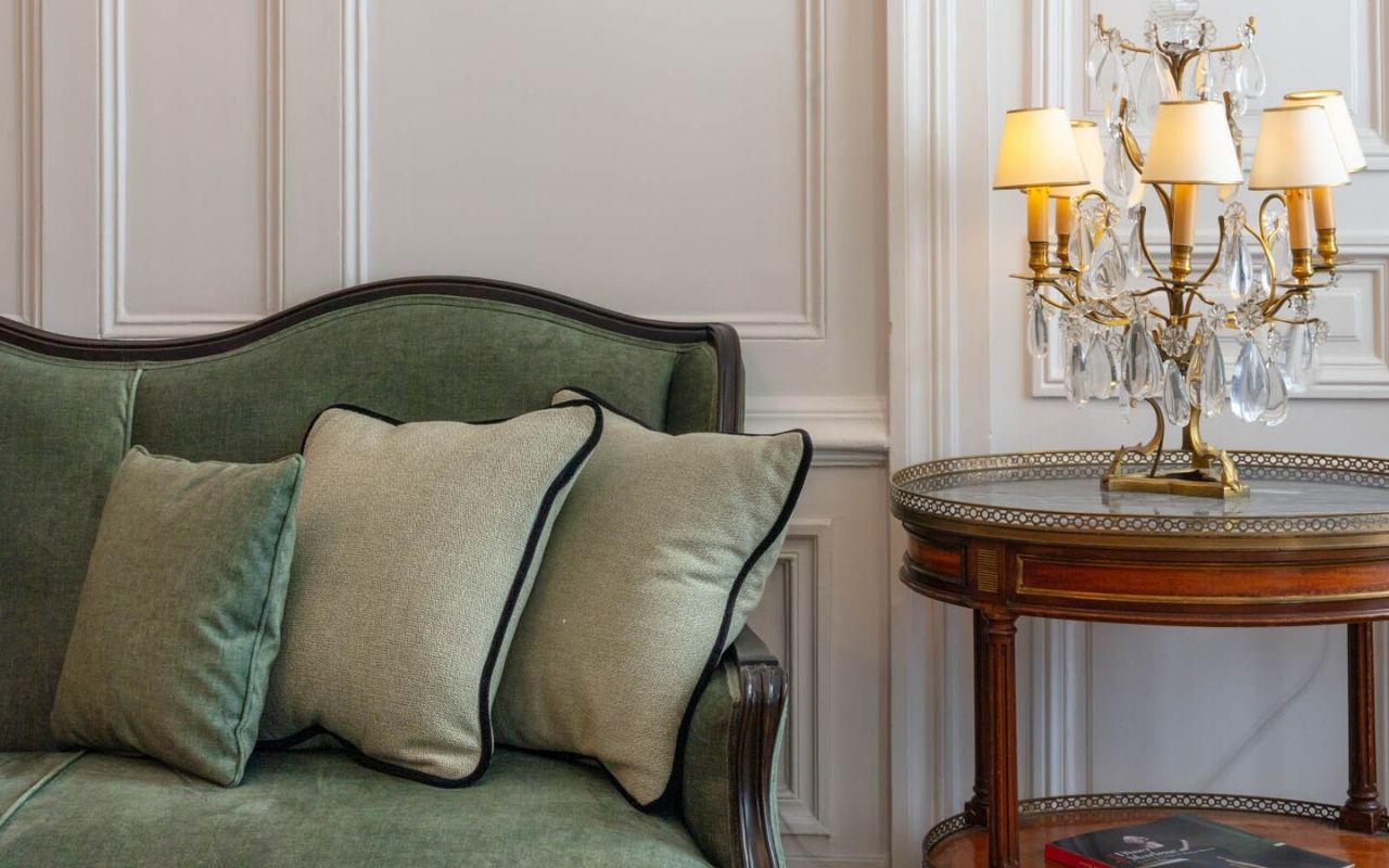 Aperçu de l'hôtel de luxe Lancaster à Paris avec son canapé vert ancien et sa lampe lustre, hôtel de luxe désigné par le studio d'architecture d'intérieur jean-philippe nuel