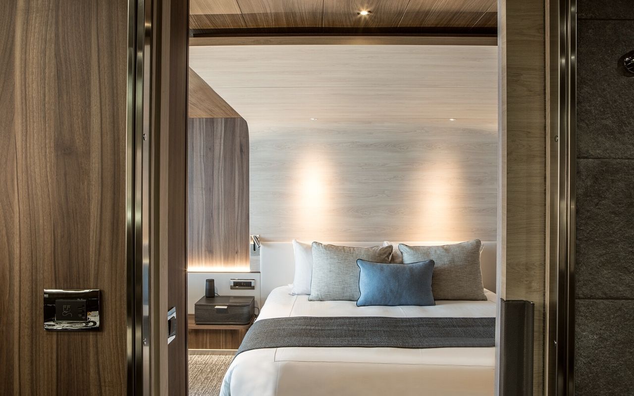 Room with a play of contrast between the woods and the maritime colors of the luxury polar cruise ship Le Commandant Charcot designed by the interior design studio jean-philippe nuel