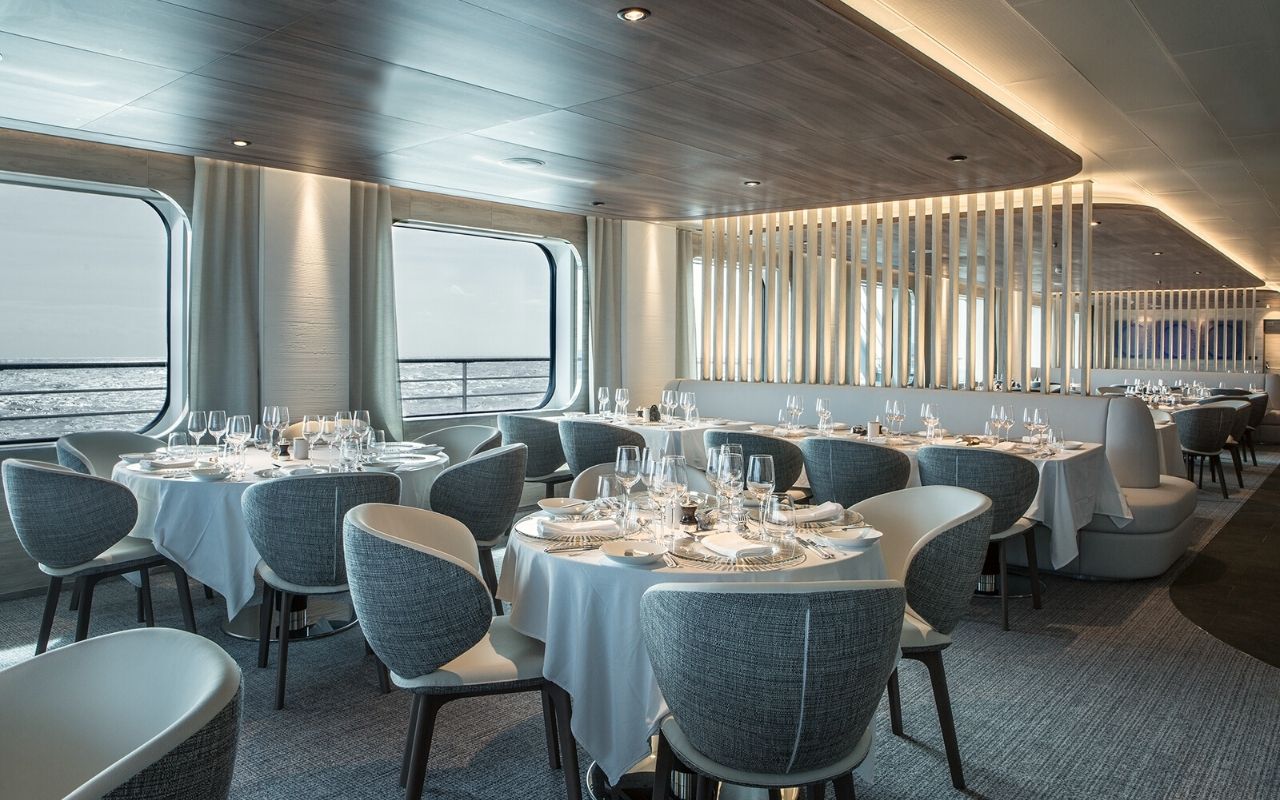 Interior restaurant with luminous ceiling like the breaking ice floe of the luxury polar cruise ship Le Commandant Charcot designed by the interior design studio jean-philippe nuel