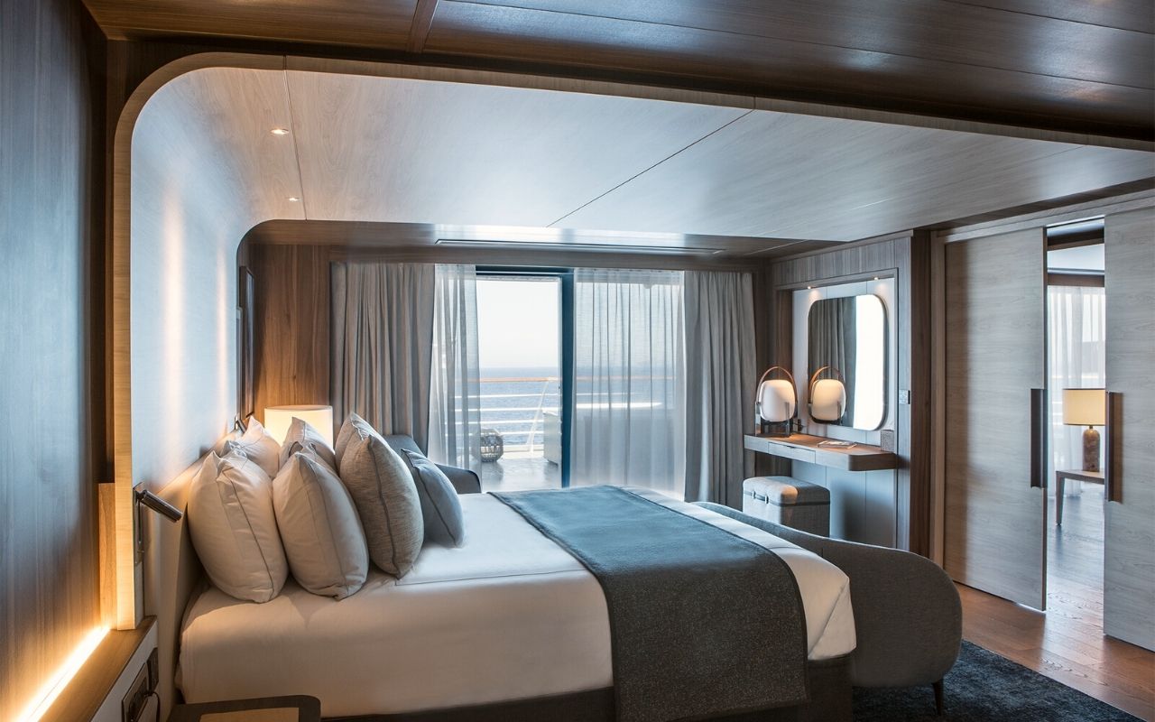 Chambre avec vue sur la mer et éclairage chaleureux du bâteau de croisière polaire de luxe Le Commandant Charcot designé par le studio d'architecture d'intérieur jean-philippe nuel