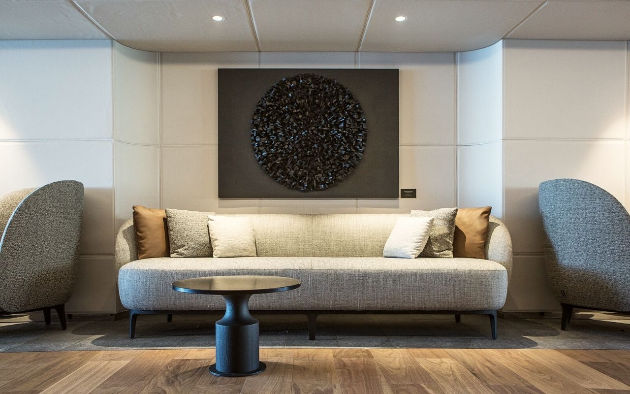 Interior salon decorated with a work of art and Ligne Roset armchairs from the luxury polar cruise ship Le Commandant Charcot designed by the interior architecture studio jean-philippe nuel