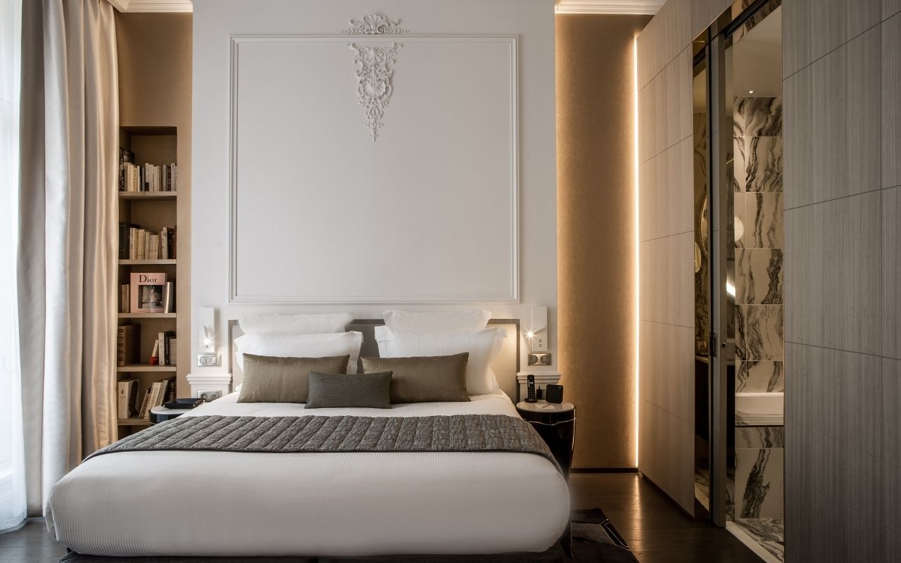 Hotel La Clef Champs-Elysées in Paris luxury room with a large bed, beautiful bookcases and moldings on the walls, luxury hotel designed by the interior design studio jean-philippe nuel