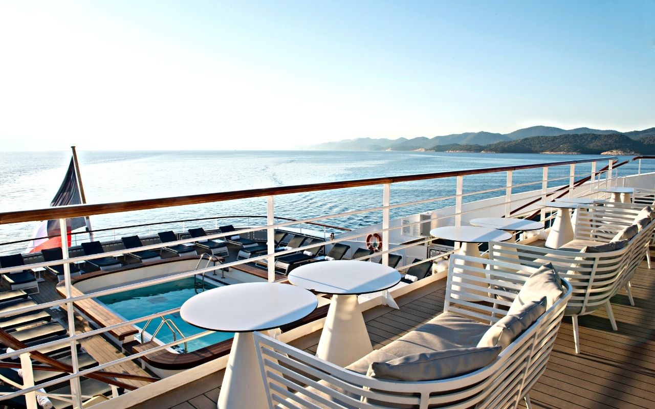 The sister ships of the Compagnie du Ponant, with terrace and view on a swimming pool on the cruise ship designed by the interior design studio jean-philippe nuel
