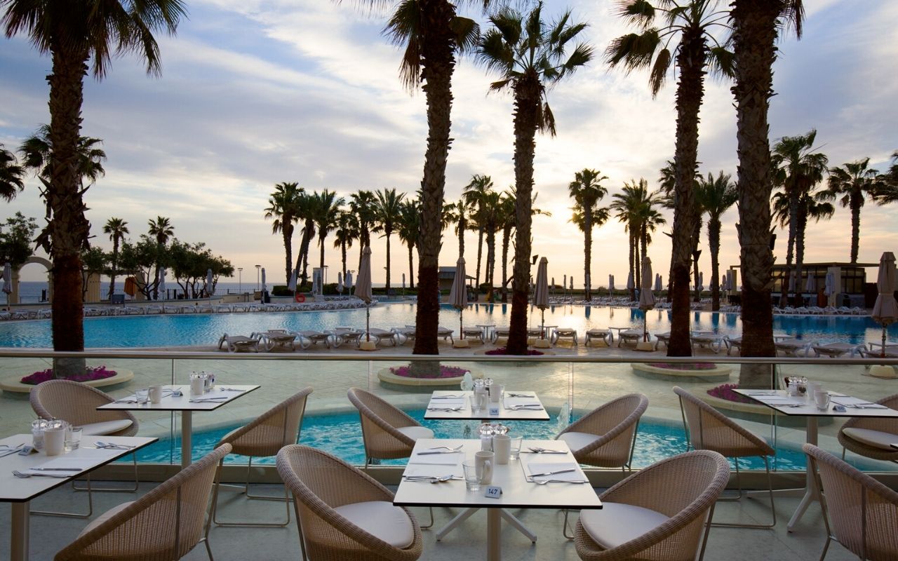Hilton Malta - hôtel de luxe désigné par le studio d'architecture d'intérieur jean-philippe nuel - restaurant extérieur- vue sur mer - style grec - piscine - palmier