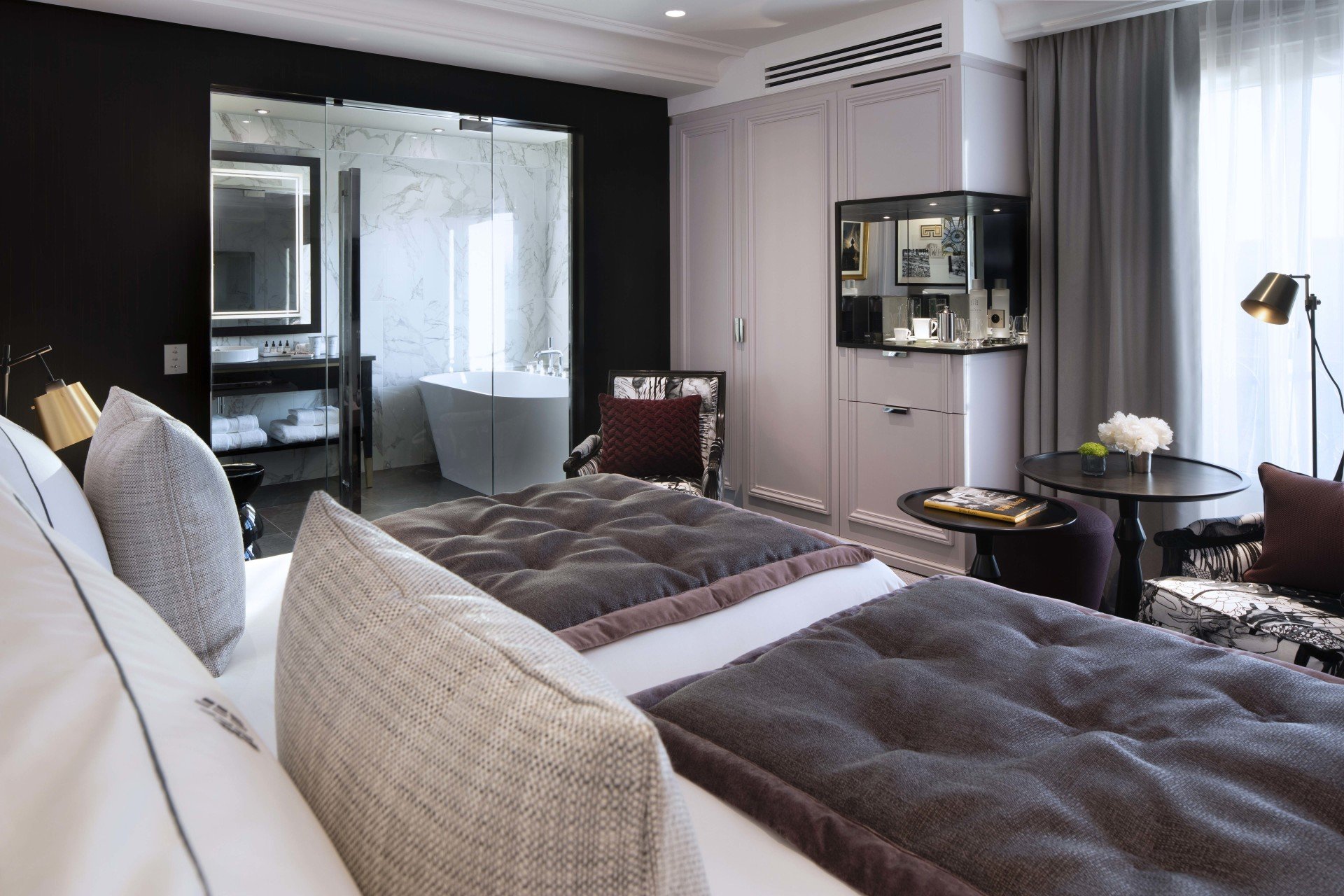 Hotel et Spa Le Damantin Paris - hôtel de luxe designé par le studio d'architecture d'intérieur jean-philippe nuel - chambre design équipée avec lit, fauteuil design, salle de bain ouverte - œuvres d'art, tableaux, hotel de rêve