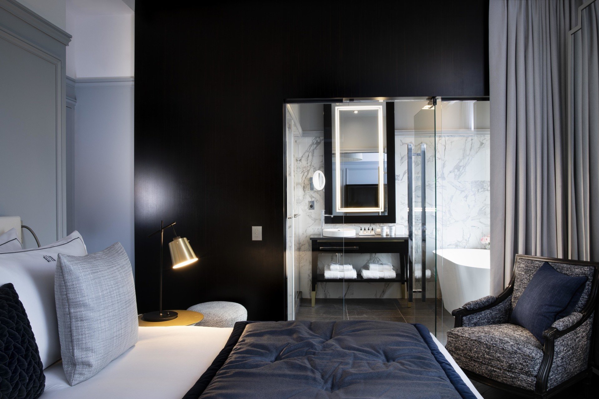 Hotel et Spa Le Damantin Paris - hôtel de luxe designé par le studio d'architecture d'intérieur jean-philippe nuel - chambre design équipée avec lit, fauteuil design, salle de bain ouverte